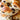 Close-up of a cinnamon raisin bagel with various toppings like apple slices and nut butter, arranged artfully.  