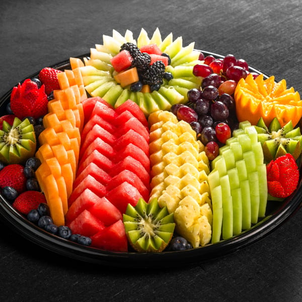A vibrant fruit platter with watermelon, cantaloupe, pineapple, kiwi, grapes, strawberries, and blueberries.